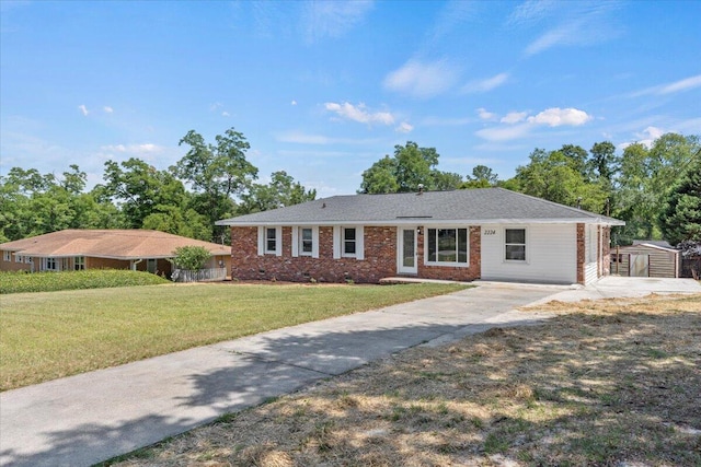 single story home with a front lawn and a storage shed