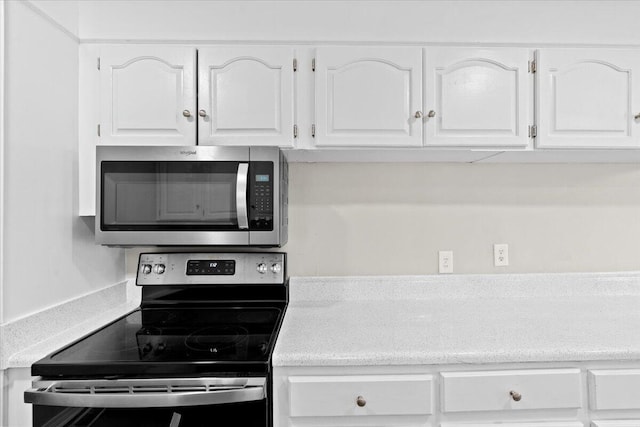 kitchen with black range with electric cooktop and white cabinetry