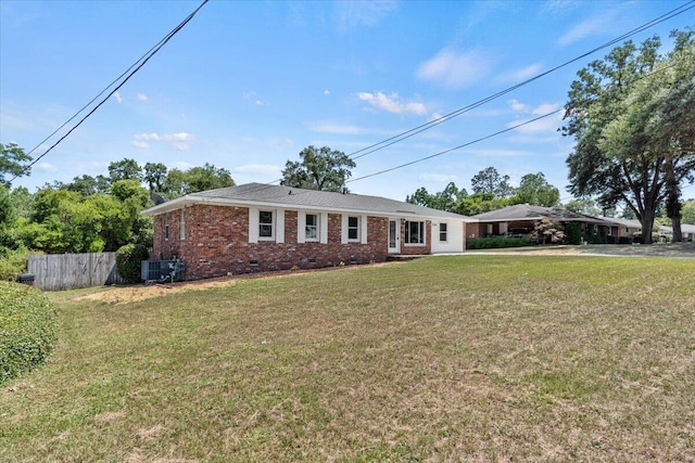 ranch-style home with central AC unit and a front yard