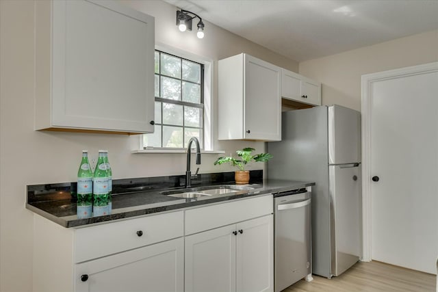 3204 Bel Ridge Rd, Augusta, GA 30909 - kitchen featuring white cabinets, stainless steel dishwasher, a sink, light wood-style floors, and dark stone counters