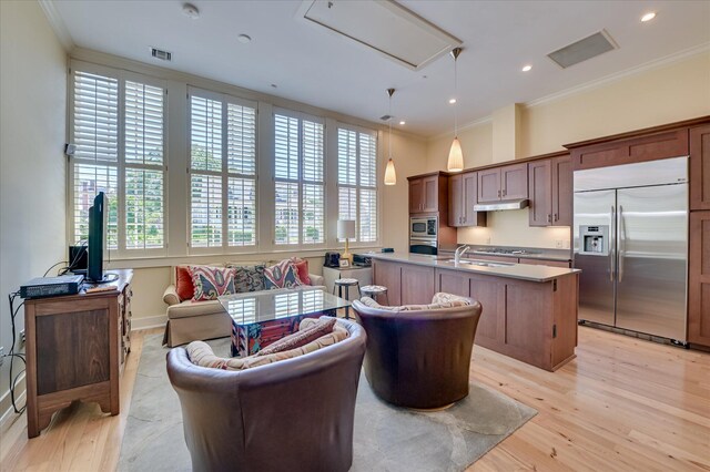 2349 Williams St, Augusta, GA 30904 - kitchen featuring built in appliances, ornamental molding, under cabinet range hood, a sink, and light wood-type flooring