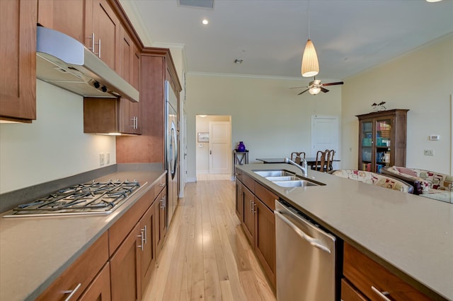 2349 Williams St, Augusta, GA 30904 - kitchen with stainless steel appliances, under cabinet range hood, a sink, ornamental molding, and brown cabinets