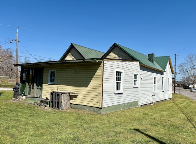 view of home's exterior featuring a lawn and metal roof