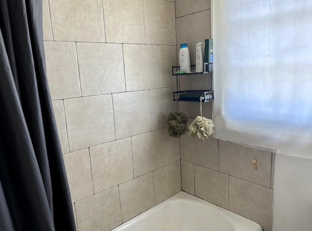 bathroom featuring a tub and a shower with curtain