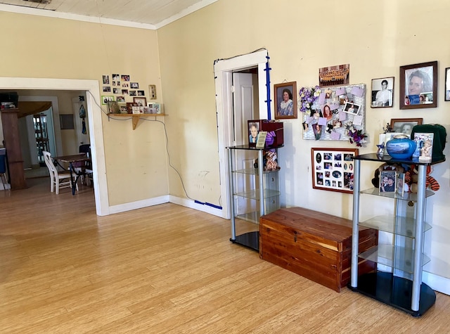 interior space featuring crown molding, wood finished floors, and baseboards