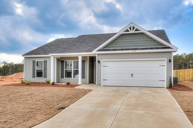 view of front of property with central AC, a front lawn, and a garage