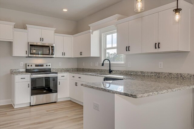 kitchen with light stone countertops, stainless steel appliances, sink, pendant lighting, and white cabinetry