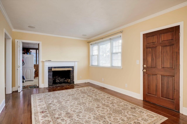 foyer entrance featuring dark wood-type flooring, a brick fireplace, and ornamental molding