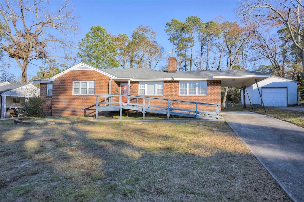 back of house featuring a lawn, a garage, and a carport