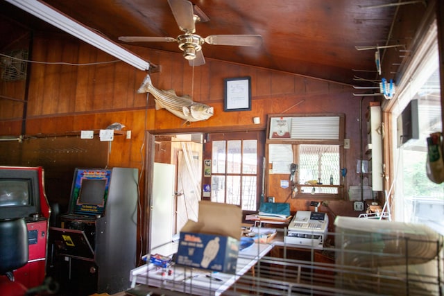 interior space featuring wood walls, ceiling fan, wood ceiling, and lofted ceiling