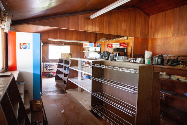 kitchen with lofted ceiling and wooden walls