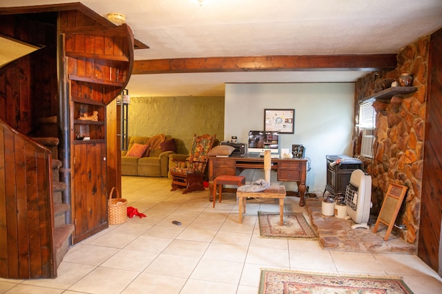 interior space featuring beam ceiling, heating unit, light tile patterned floors, and a wood stove