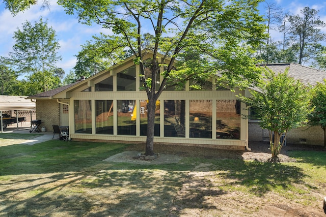 4065 S Goshen Lake Dr, Augusta, GA 30906 - back of house with brick siding, a yard, roof with shingles, and a sunroom