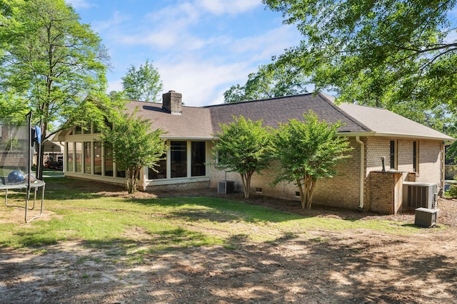 4065 S Goshen Lake Dr, Augusta, GA 30906 - back of house with a trampoline, a chimney, cooling unit, brick siding, and a sunroom
