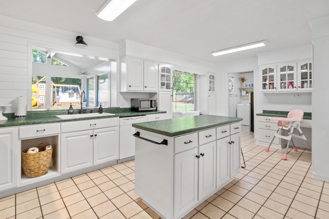 4065 S Goshen Lake Dr, Augusta, GA 30906 - kitchen with stainless steel microwave, light tile patterned floors, dark countertops, white dishwasher, and a sink
