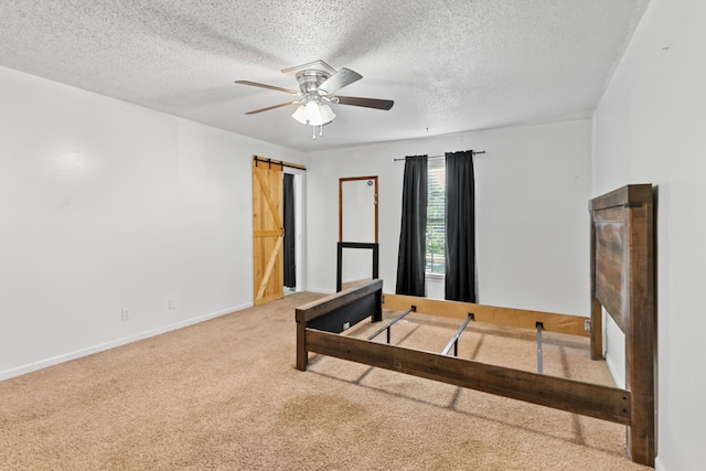 4065 S Goshen Lake Dr, Augusta, GA 30906 - unfurnished bedroom with baseboards, carpet flooring, a textured ceiling, a barn door, and ceiling fan
