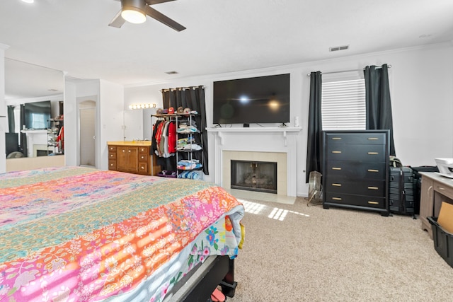 4065 S Goshen Lake Dr, Augusta, GA 30906 - carpeted bedroom with a ceiling fan, a tiled fireplace, ornamental molding, and visible vents
