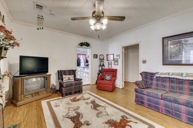 living room featuring hardwood / wood-style flooring, ceiling fan, and crown molding