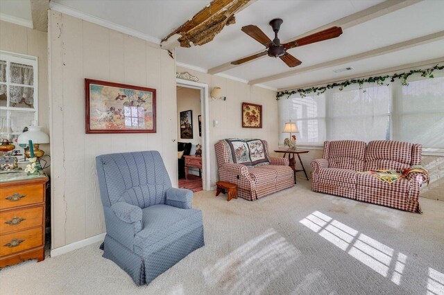 living room with ceiling fan, beamed ceiling, and ornamental molding