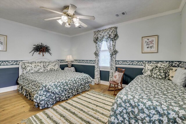 bedroom with ceiling fan, crown molding, and a textured ceiling