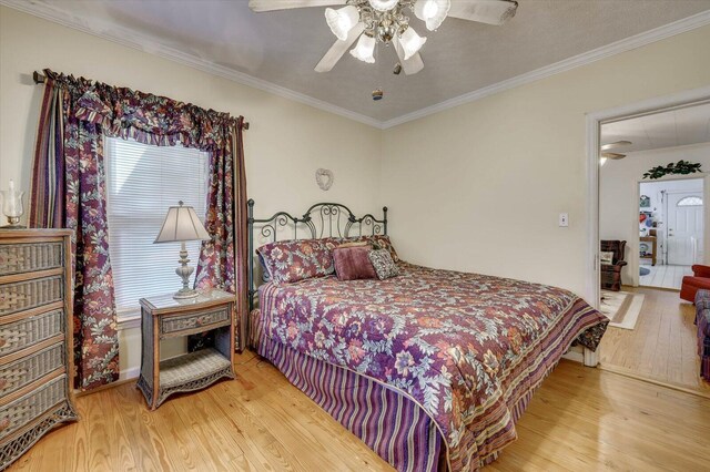 bedroom featuring hardwood / wood-style floors, ceiling fan, and crown molding