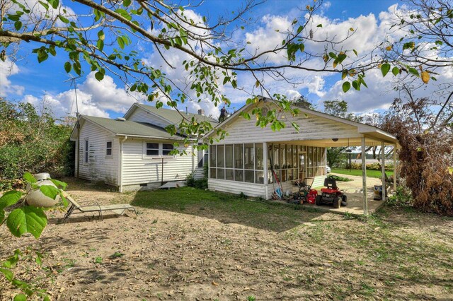 back of property featuring a carport and a sunroom