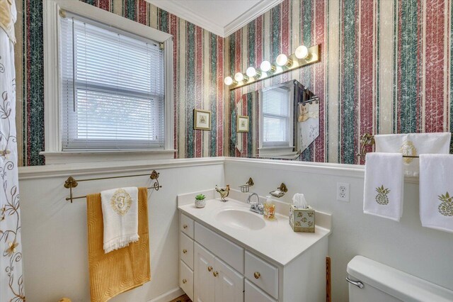 bathroom with vanity, toilet, and ornamental molding