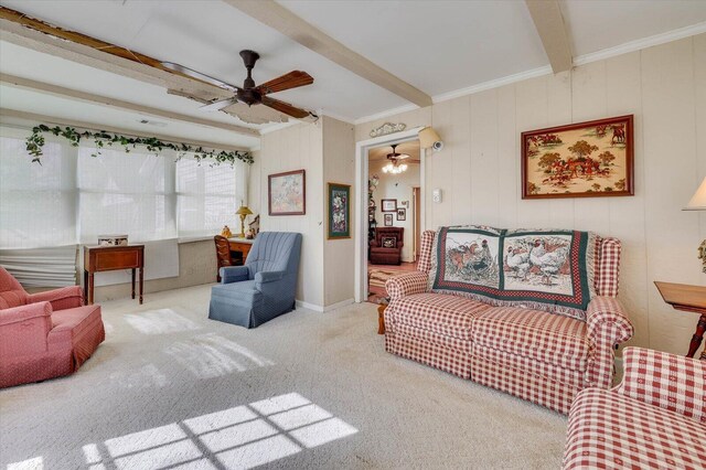 living room featuring carpet, ceiling fan, beamed ceiling, and ornamental molding