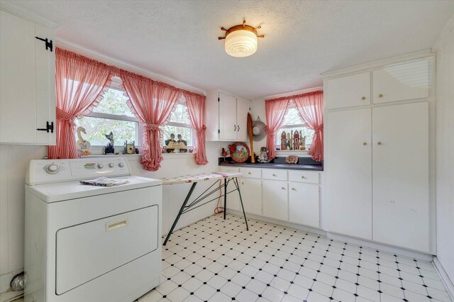 laundry room with washer / clothes dryer, plenty of natural light, cabinets, and a textured ceiling