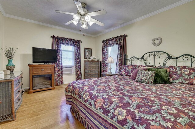 bedroom featuring a textured ceiling, light hardwood / wood-style floors, ceiling fan, and crown molding