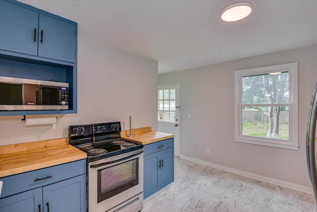2325 Henry Cir, Augusta, GA 30906 - kitchen featuring butcher block countertops, stainless steel appliances, blue cabinets, light marble finish flooring, and baseboards