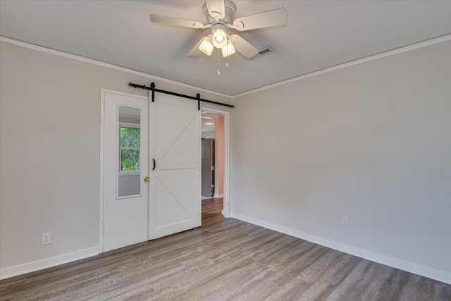 2325 Henry Cir, Augusta, GA 30906 - unfurnished room featuring wood finished floors, baseboards, ornamental molding, a ceiling fan, and a barn door