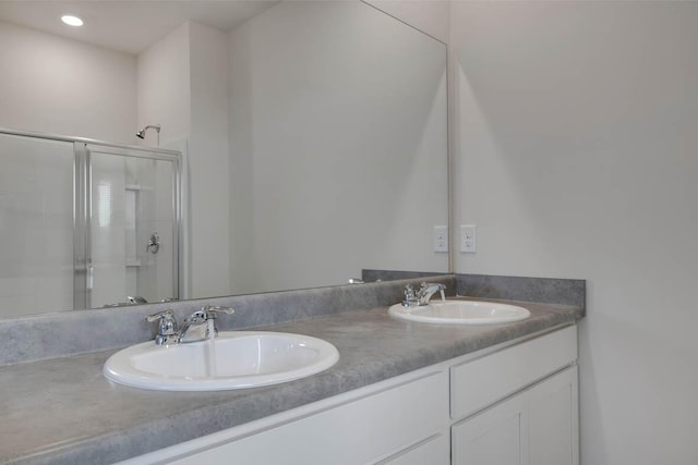 bathroom featuring vanity and a shower with shower door