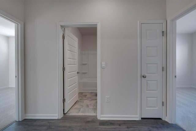 corridor featuring dark colored carpet