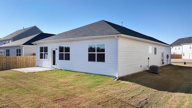 back of house with central AC unit, a lawn, and a patio