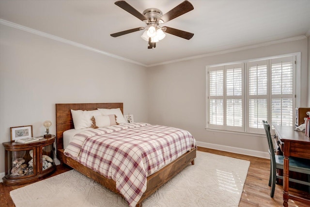 bedroom with baseboards, ceiling fan, wood finished floors, and crown molding