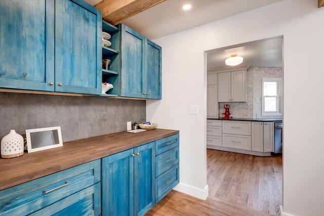 kitchen featuring butcher block countertops and blue cabinetry