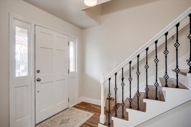 entryway featuring stairs, wood finished floors, and baseboards