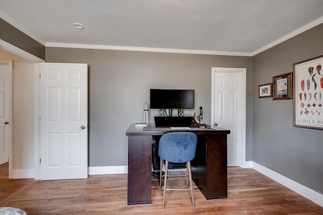 office with light wood-style flooring, ornamental molding, and baseboards