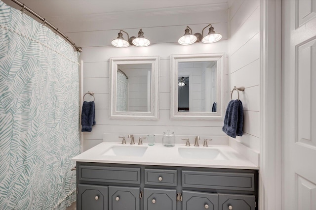 bathroom featuring double vanity, ornamental molding, and a sink