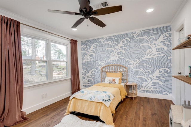 bedroom featuring visible vents, ornamental molding, wood finished floors, baseboards, and wallpapered walls