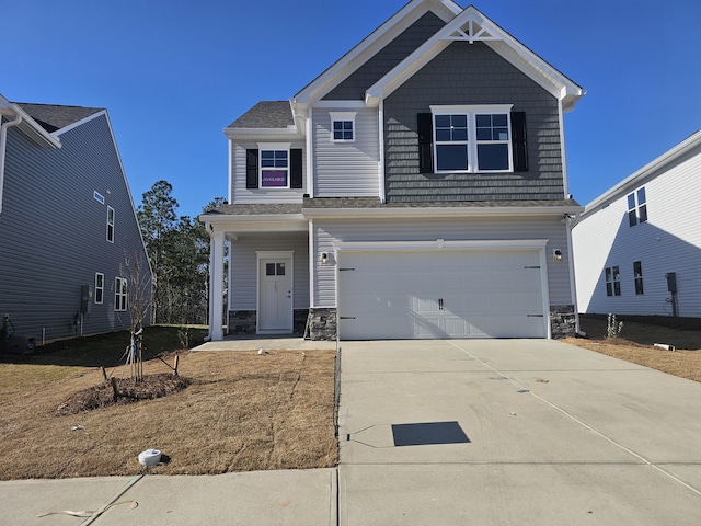 craftsman inspired home with an attached garage, stone siding, and concrete driveway