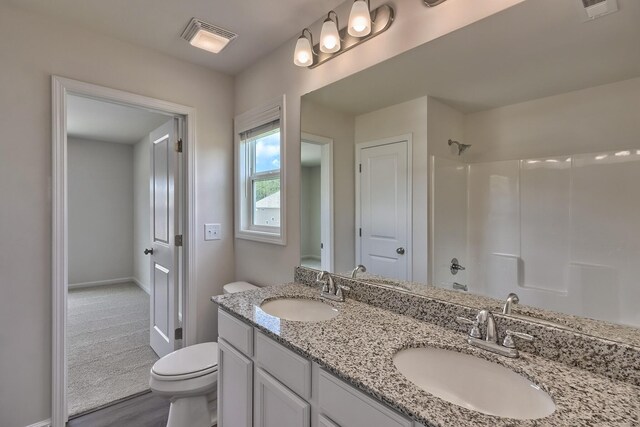 bathroom with visible vents, a sink, toilet, and walk in shower