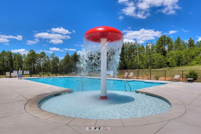 community pool featuring fence and a patio