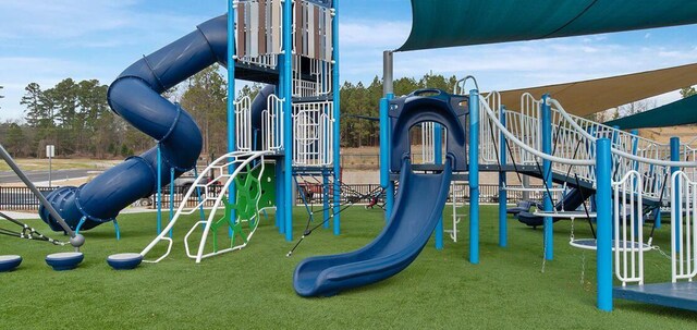 community jungle gym featuring a lawn