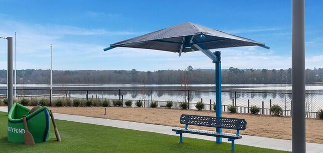 view of property's community with a water view and fence