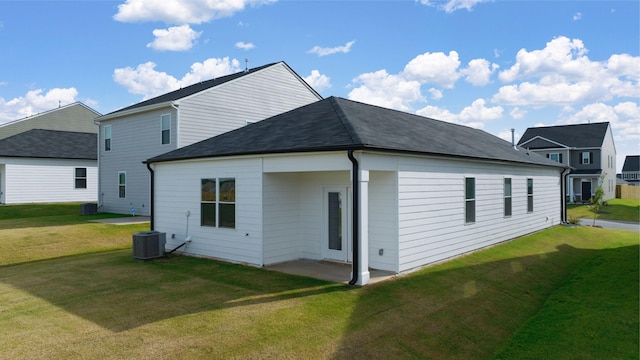 rear view of property with central air condition unit, a yard, and a patio area