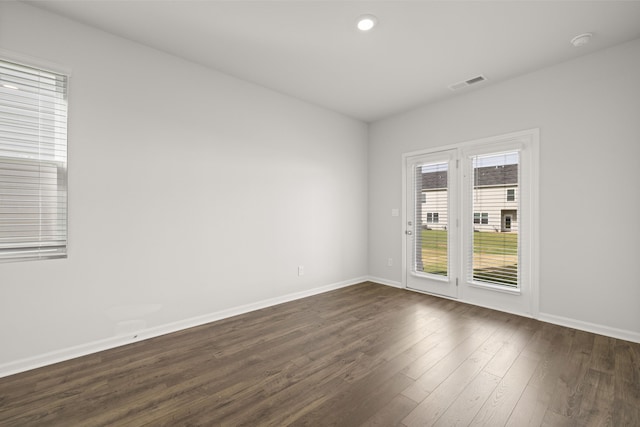 unfurnished room with visible vents, recessed lighting, dark wood-type flooring, and baseboards