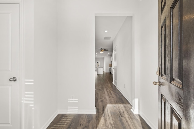 corridor with visible vents, baseboards, and wood finished floors