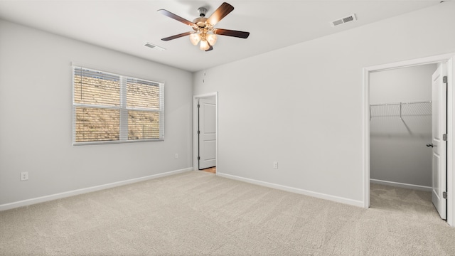 carpeted empty room featuring visible vents, baseboards, and ceiling fan